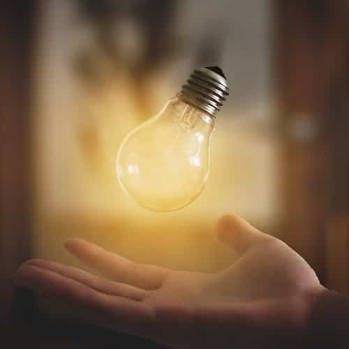 Die Hand einer Person hält eine Glühbirne.